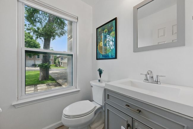 The convenient half bathroom features contemporary finishes, providing a stylish and functional space for guests and daily use. | Image 25