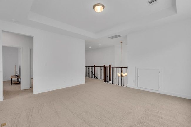Unfurnished room featuring carpet floors, a raised ceiling, recessed lighting, and a chandelier | Image 24