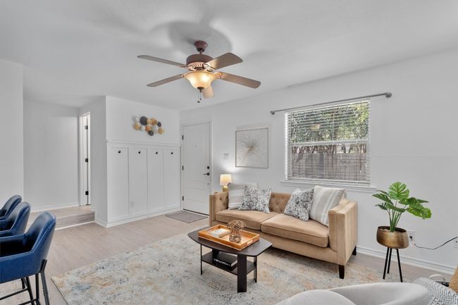 Natural light pours in through the large windows, making the living room bright and inviting. | Image 8