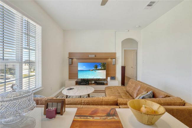 Living room featuring arched walkways, plenty of natural light, and ceiling fan | Image 25