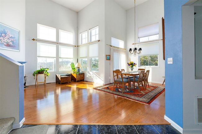 Dining room featuring hardwood / wood-style flooring, a towering ceiling, and an inviting chandelier | Image 5