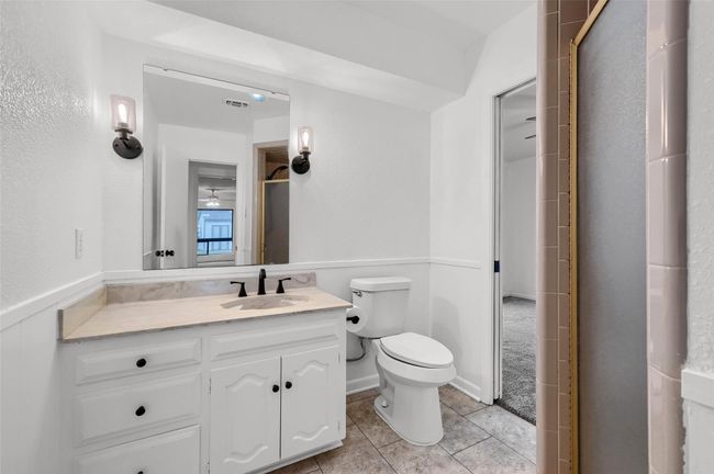 Bathroom featuring vanity, tile patterned floors, toilet, and a shower with shower door | Image 22
