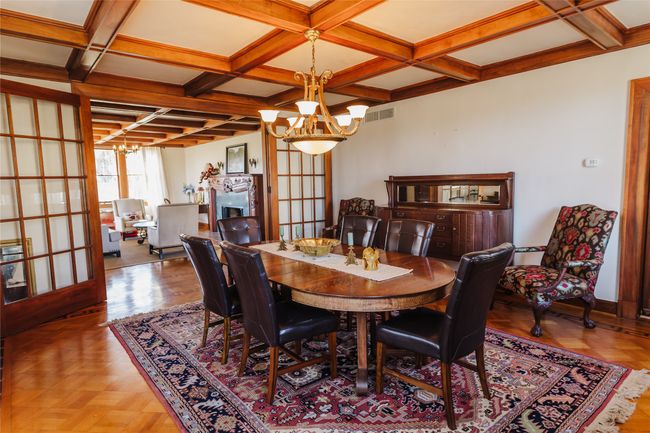 Dining room with coffered ceiling, parquet floors, french doors, a chandelier, and beamed ceiling | Image 9