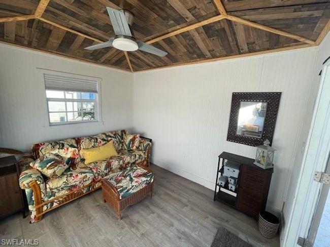 Living room featuring ornamental molding, vaulted ceiling, ceiling fan, wooden ceiling, and hardwood / wood-style floors | Image 12
