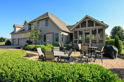 Rear view of house with a sunroom and a garage | Image 3