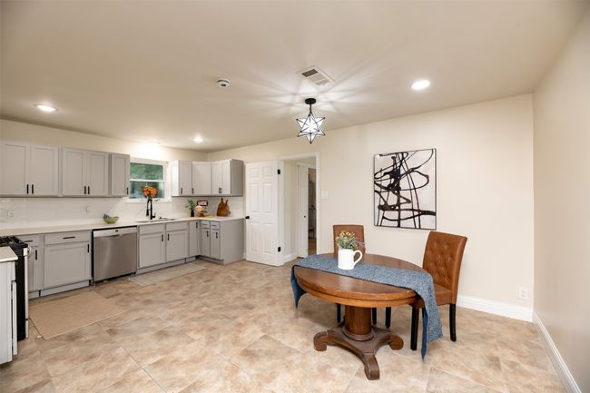 Kitchen with stainless steel dishwasher, gray cabinets, light countertops, a sink, and recessed lighting | Image 7