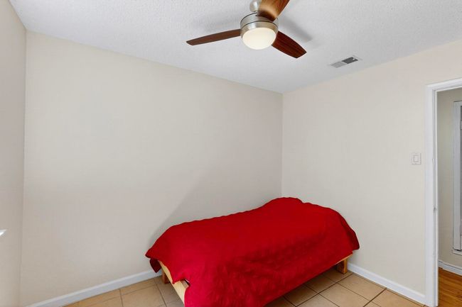 Bedroom featuring ceiling fan, tile patterned flooring, and a textured ceiling | Image 13