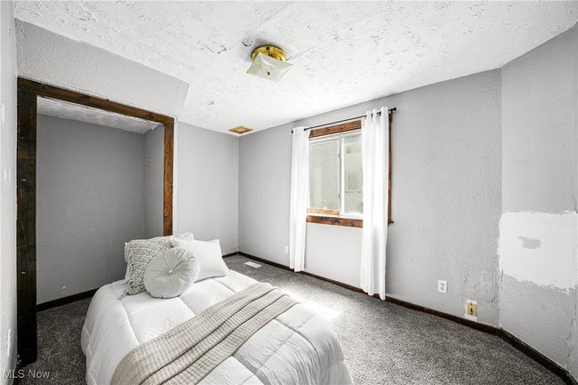 Carpeted bedroom featuring a textured wall, a textured ceiling, and baseboards | Image 15