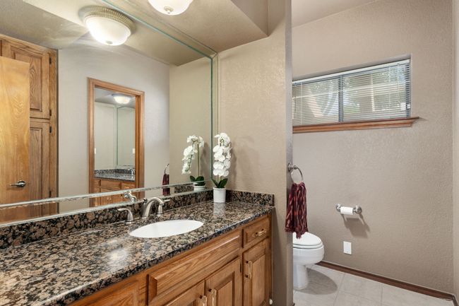 Bathroom with tile patterned floors, vanity, toilet, and baseboards | Image 19