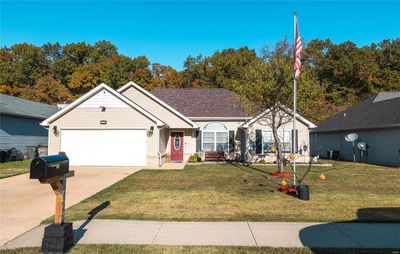 Ranch-style house featuring a front lawn and a garage | Image 1