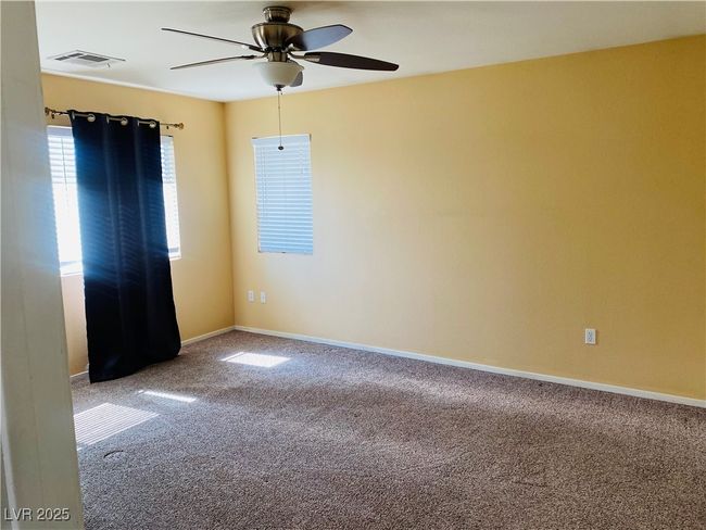Carpeted spare room with visible vents, baseboards, and a ceiling fan | Image 12