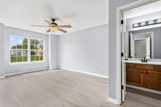 Kitchen with light wood-style floors, black microwave, a ceiling fan, light countertops, and electric range | Image 9