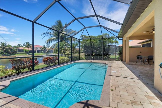 Outdoor pool featuring a patio area, glass enclosure, and a ceiling fan | Image 5