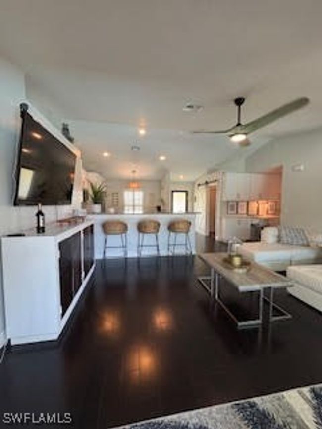 Living area featuring a ceiling fan, lofted ceiling, and wood finished floors | Image 12