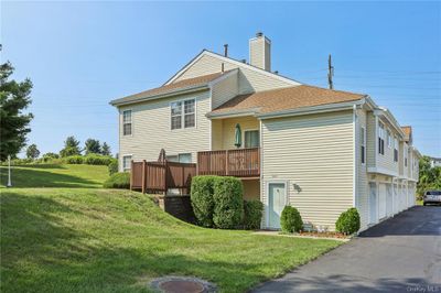 Rear view of house featuring a garage and a lawn | Image 1