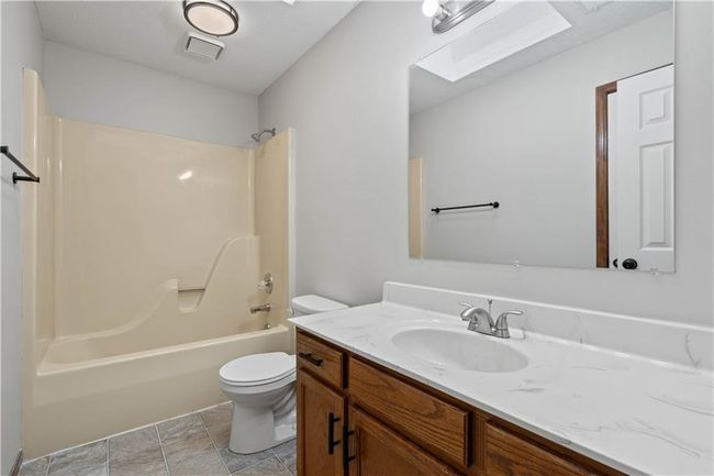 Bathroom featuring toilet, tub / shower combination, vanity, and visible vents | Image 29