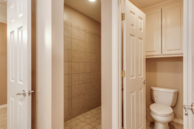 Bathroom featuring toilet, tiled shower, and tile patterned floors | Image 22