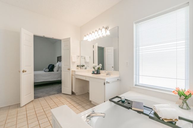 Bathroom with a bath, connected bathroom, tile patterned floors, and a sink | Image 30
