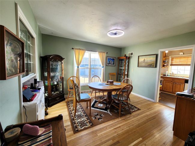 Dining room with visible vents, baseboards, and light wood-type flooring | Image 17