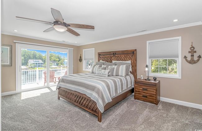 Bedroom featuring access to exterior, multiple windows, ornamental molding, carpet floors, and a ceiling fan | Image 22