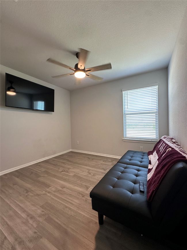 Living area with baseboards, a ceiling fan, wood finished floors, and a textured ceiling | Image 12