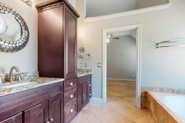 Full bathroom with a sink, crown molding, double vanity, a relaxing tiled tub, and lofted ceiling | Image 23