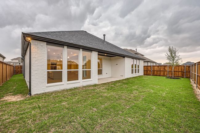 Rear view of house featuring brick siding, a fenced backyard, and a yard | Image 28