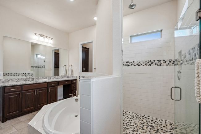 Full bath featuring a bath, two vanities, and a stall shower | Image 27