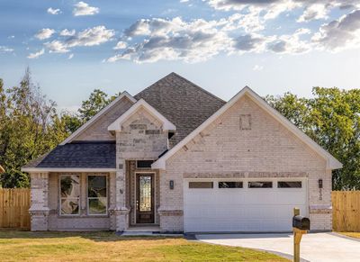 View of front facade featuring a front yard and a garage | Image 1