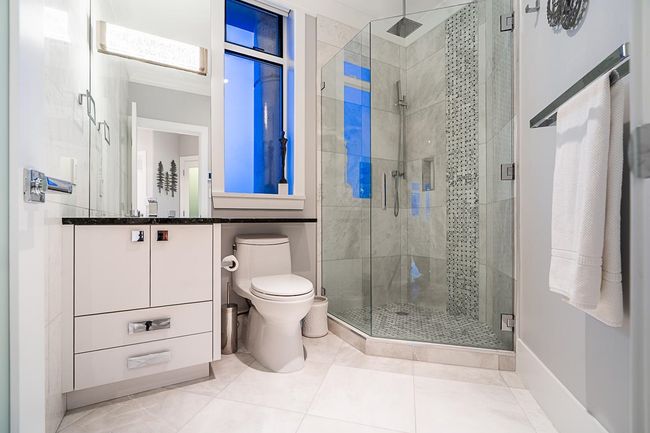 Full bathroom with vanity, a shower stall, toilet, and baseboards | Image 30