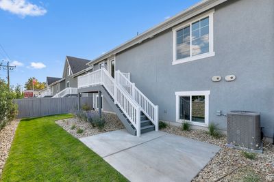 Rear view of house with a yard, central AC unit, and a patio area | Image 3