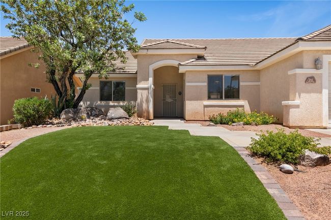 View of front of home with stucco siding, a front yard, and a tile roof | Image 4