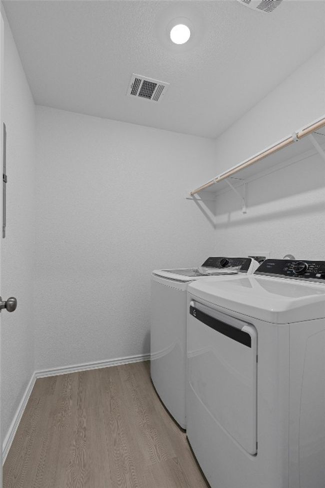 Washroom featuring washing machine and dryer and light wood finished floors | Image 24