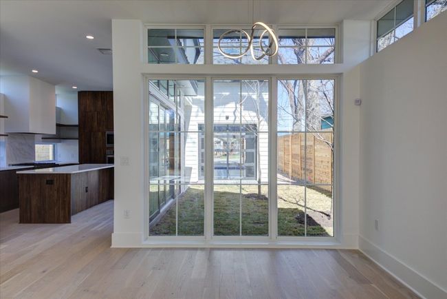 The open kitchen/dining areas are flooded with natural light and conveniently located next to the yard/courtyard area that could easily accommodate a deck or pool. | Image 13