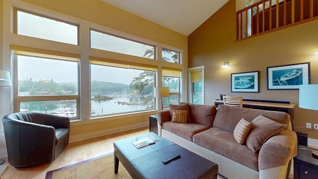 Living room featuring high vaulted ceiling, a water view, baseboards, and hardwood / wood-style flooring | Image 13