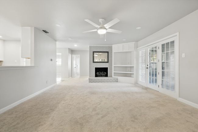 Unfurnished living room with recessed lighting, a wealth of natural light, a ceiling fan, and baseboards | Image 16