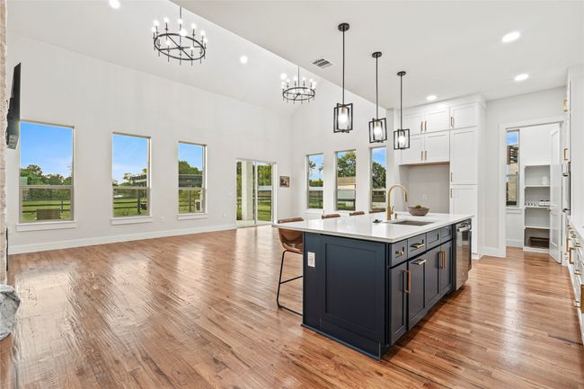 Kitchen featuring a chandelier, open floor plan, white cabinetry, light countertops, and recessed lighting | Image 5