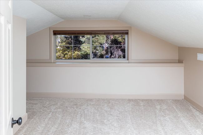 Additional living space featuring carpet flooring, vaulted ceiling, and a textured ceiling | Image 35