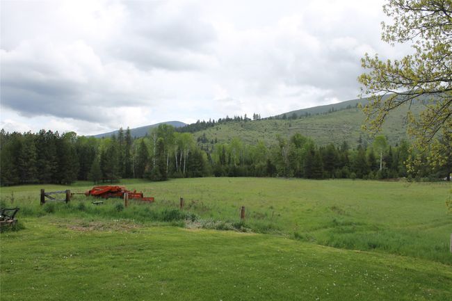 View of green lawn featuring a view of countryside, a mountain view, and a view of trees | Image 10