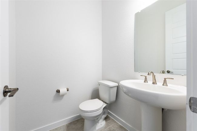 Half bath with baseboards, toilet, tile patterned flooring, and a sink | Image 22