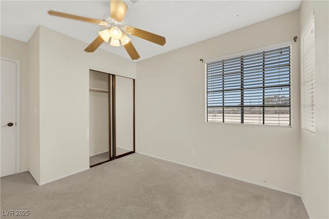 Unfurnished bedroom with a ceiling fan, a closet, and light colored carpet | Image 33