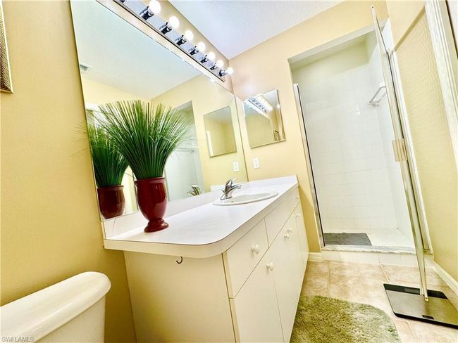 Bathroom featuring a shower stall, toilet, vanity, and baseboards | Image 21
