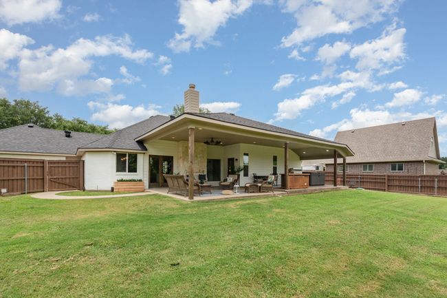 Back of house featuring a fenced backyard, a chimney, a patio, and ceiling fan | Image 35
