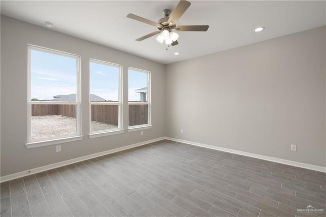 Unfurnished room featuring ceiling fan, baseboards, dark wood finished floors, and recessed lighting | Image 6