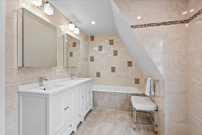 Full bath with tile walls, tiled tub, and a sink | Image 12