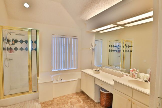 Bathroom with double vanity, a stall shower, a garden tub, and vaulted ceiling | Image 18