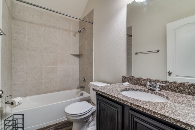 Bathroom with vanity, shower / bath combination, wood finished floors, and a textured wall | Image 22