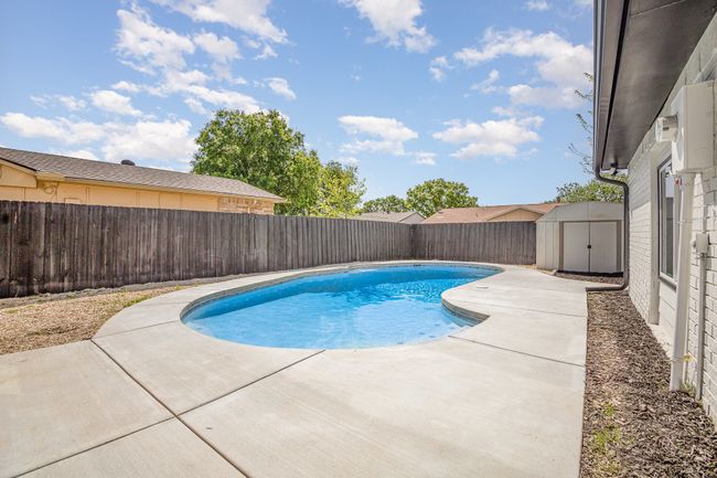 View of pool featuring a fenced backyard, an outdoor structure, a storage unit, a patio area, and a fenced in pool | Image 28