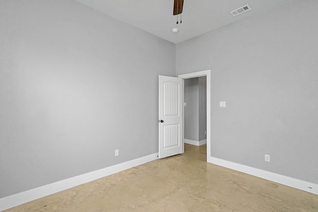 Unfurnished room with finished concrete floors, baseboards, and ceiling fan | Image 14