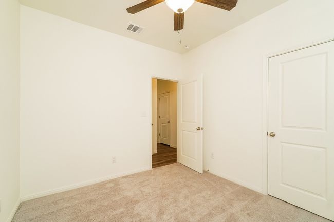 Unfurnished bedroom featuring light colored carpet and a ceiling fan | Image 17